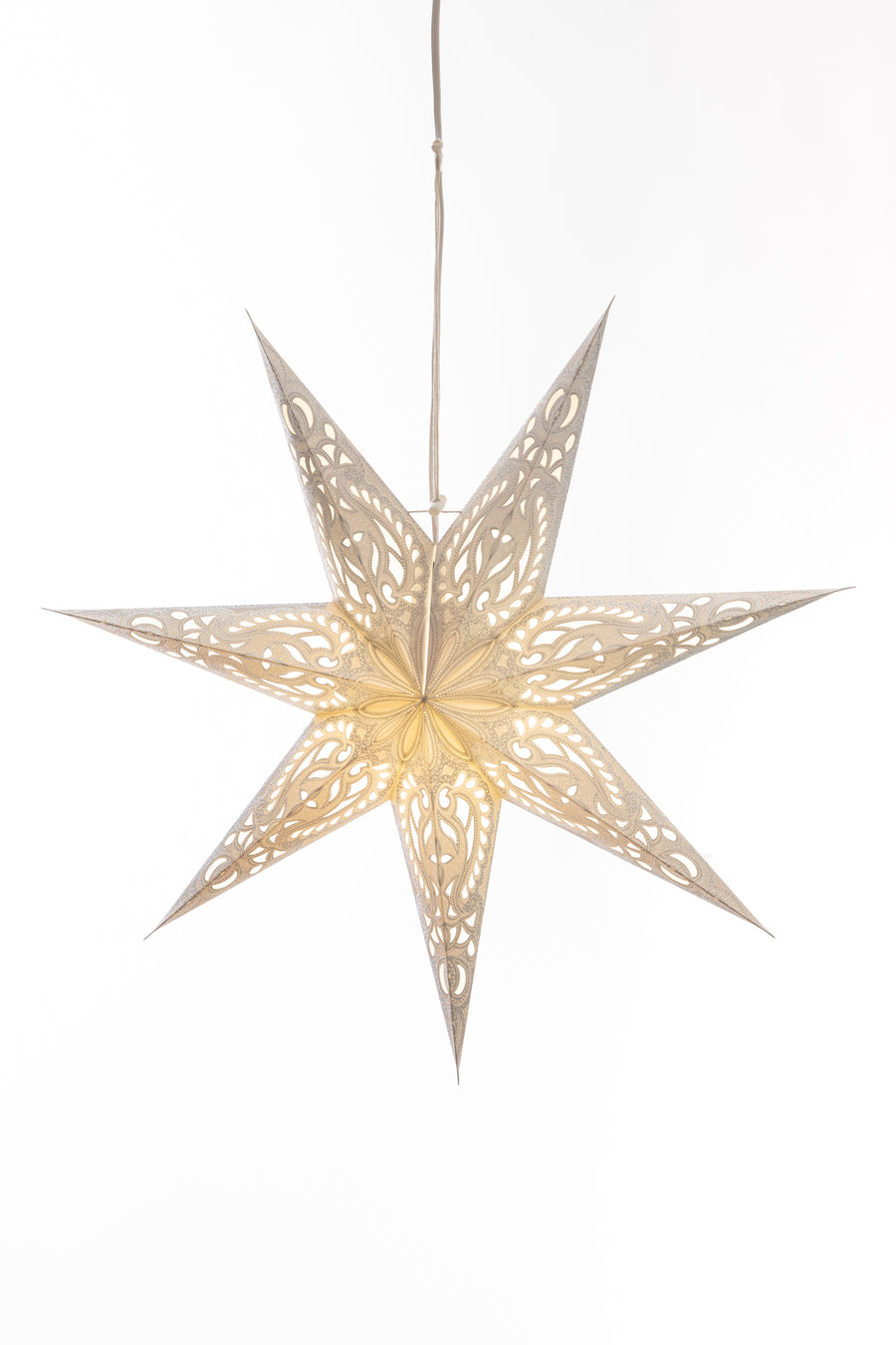 White 7-point paper star lantern hanging in front of a white wall. 