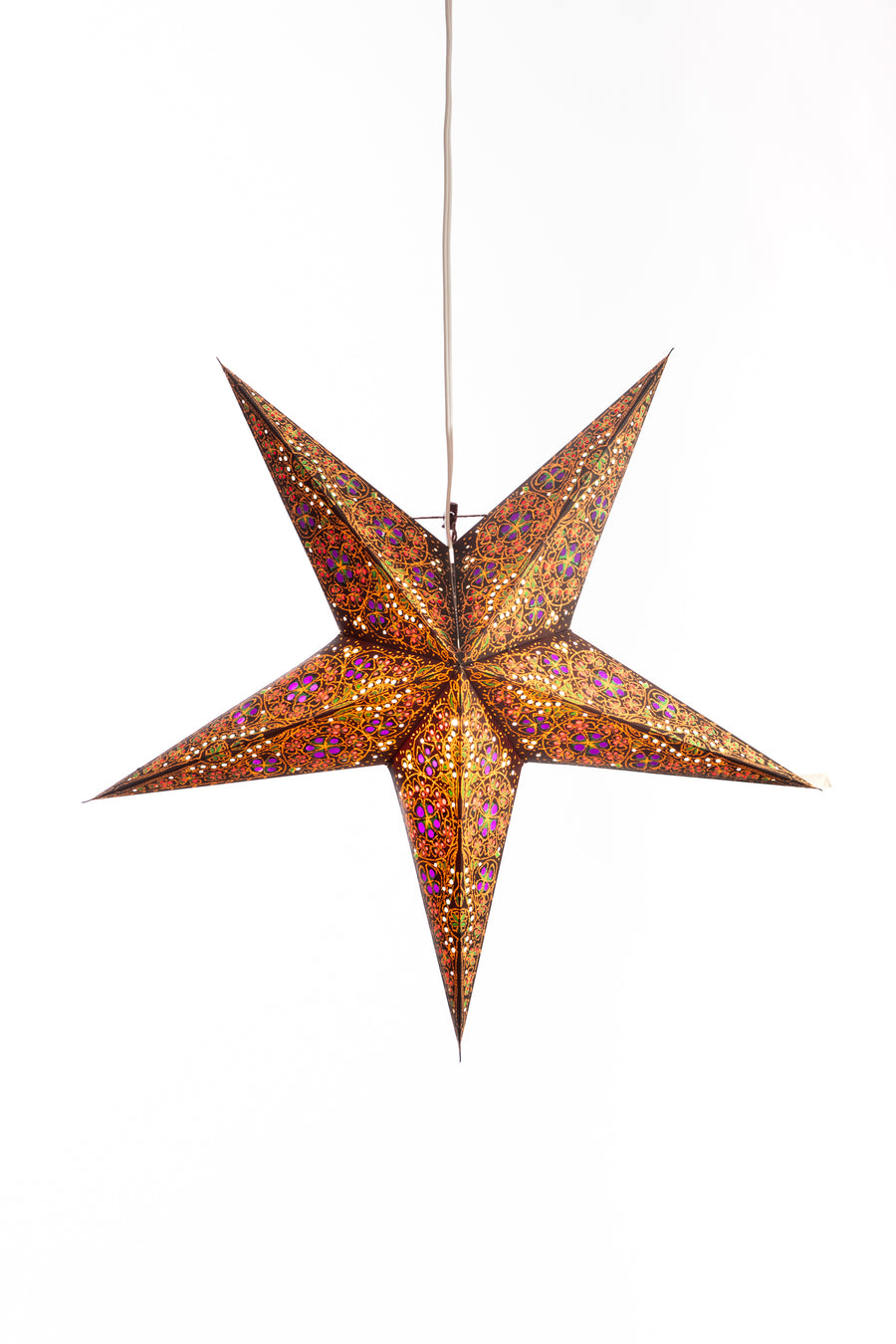 An orange and brown patterned star lantern hanging in front of a white backdrop 